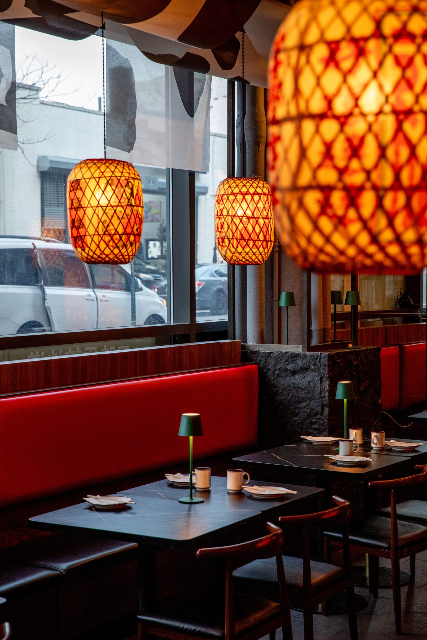 Window-side booths with red lanterns at Hunan Tapas, an Hunan Restaurant in NY