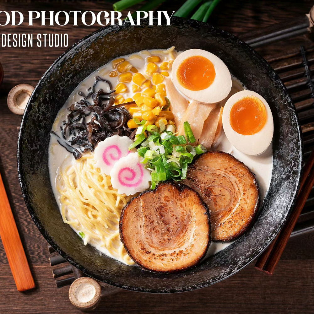 Japanese ramen served in a black bowl with creamy broth, sliced chashu pork, soft-boiled eggs, noodles, corn, mushrooms, bamboo shoots, and green onions.