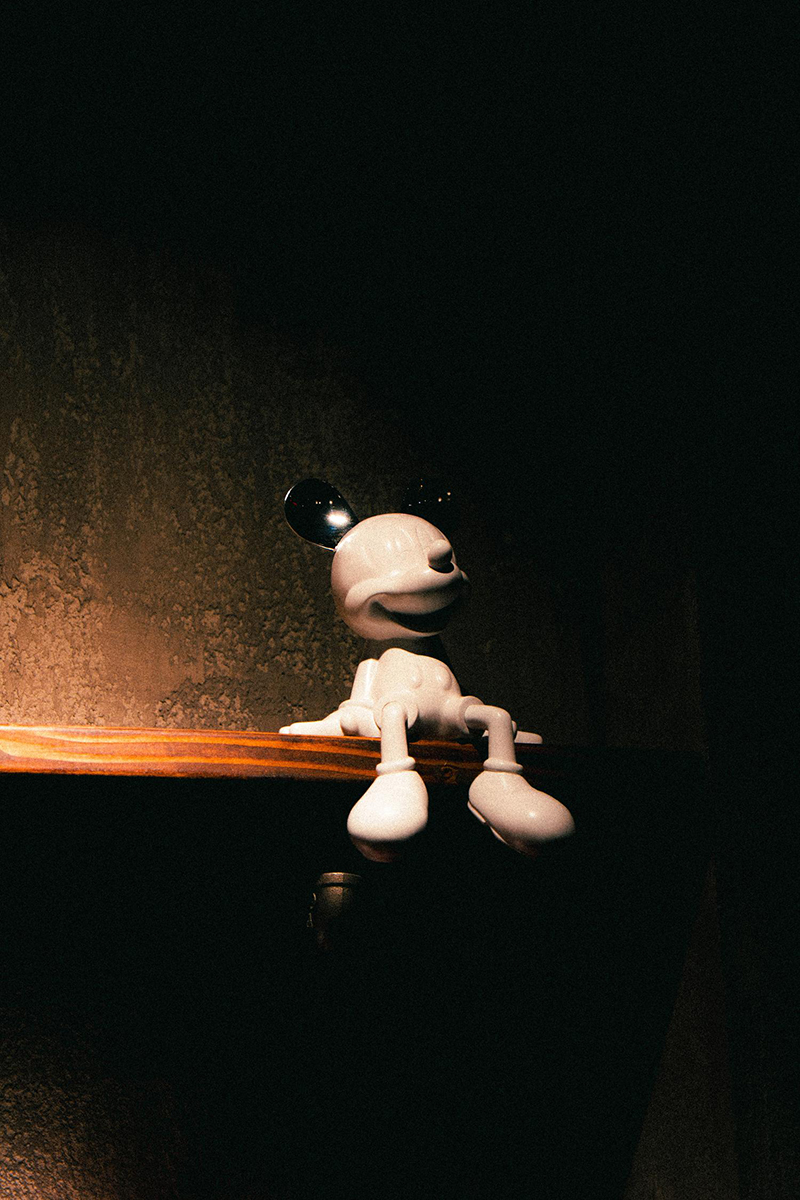 White Mickey Mouse figurine on wooden shelf at 梦幻冰季 - ICERA，a Asian Fusion BBQ Restaurant in New York