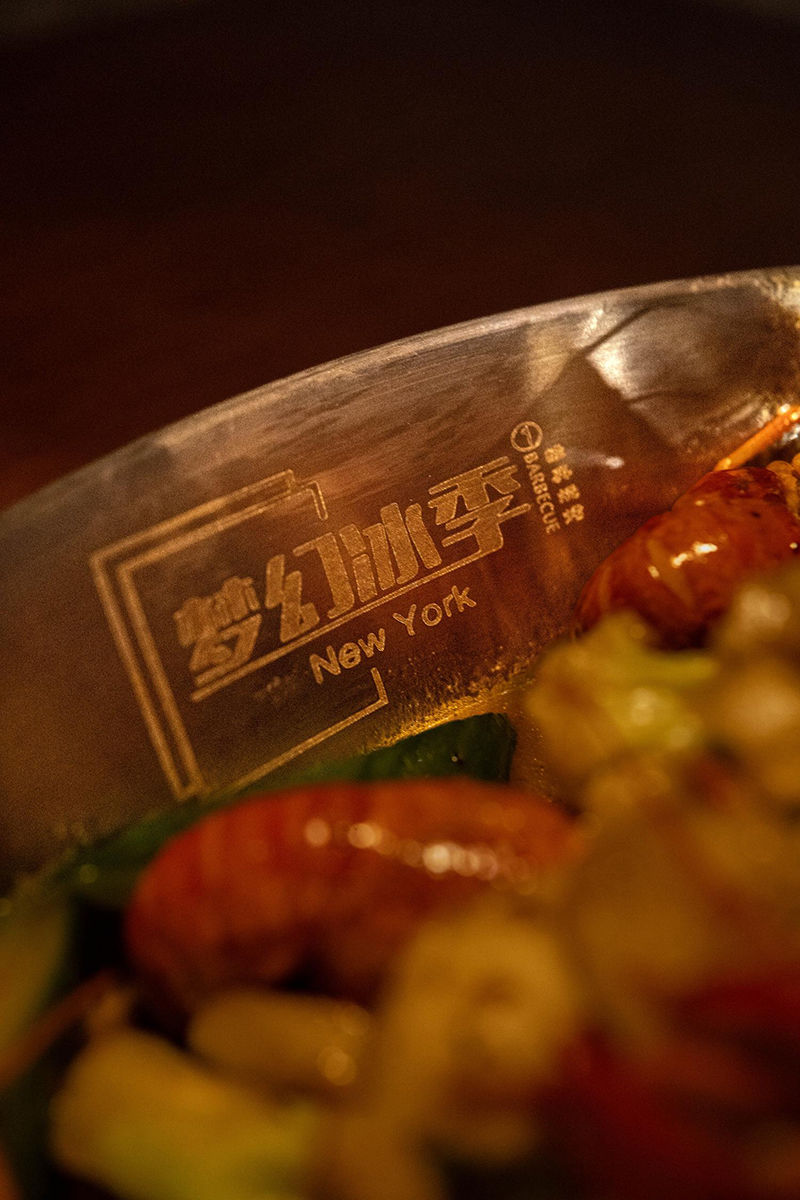 Close-up of metal pot engraved with "梦幻冰季 New York" logo at 梦幻冰季 - ICERA，a Asian Fusion BBQ Restaurant in New York