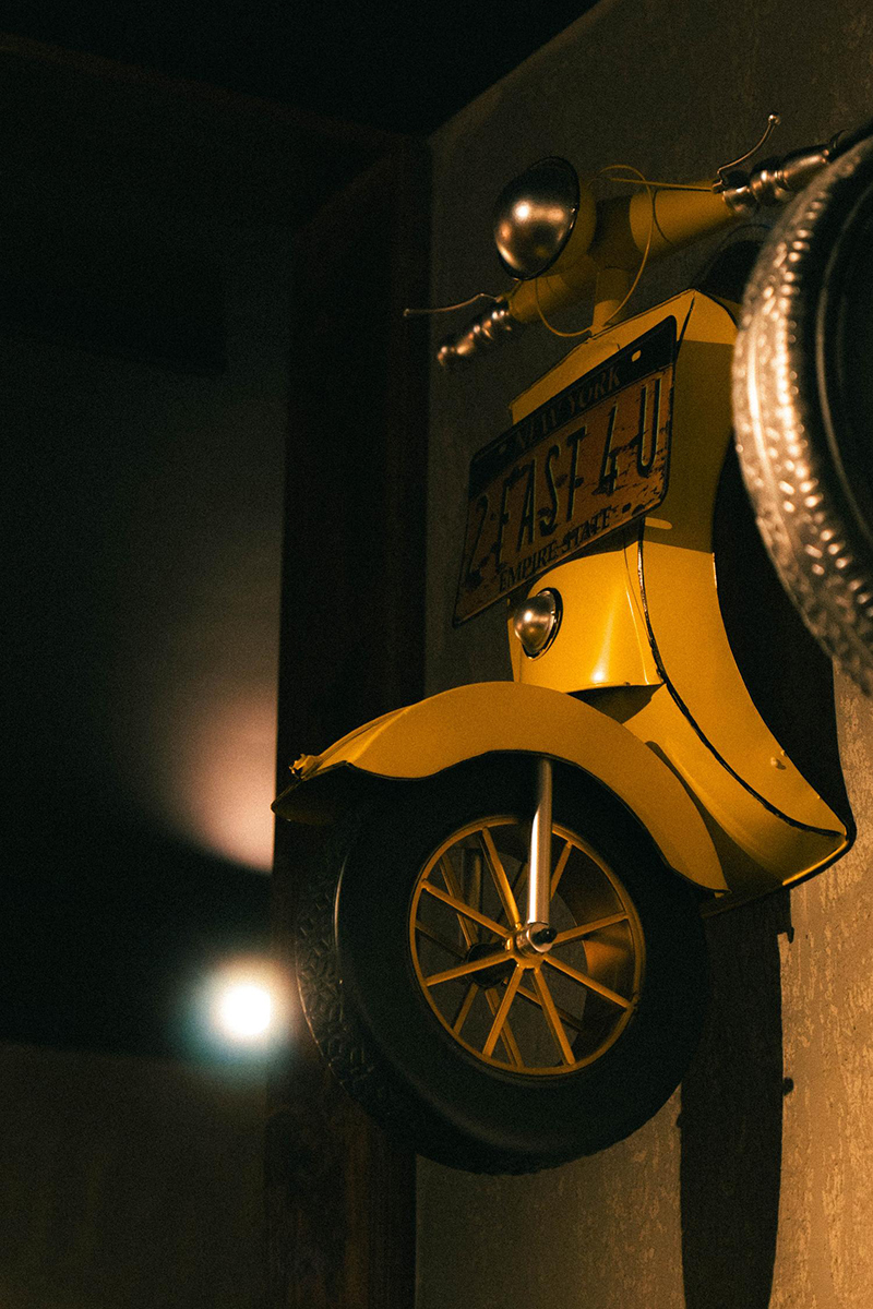 Yellow vintage scooter wall decor with NY license plate at 梦幻冰季 - ICERA，a Asian Fusion BBQ Restaurant in New York