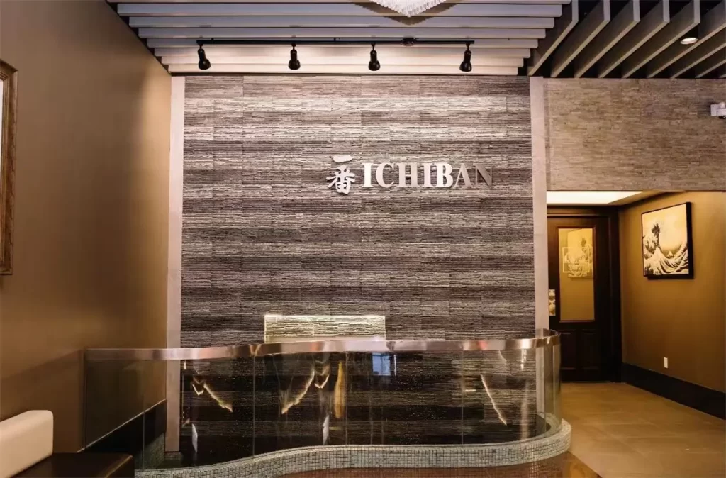 Stone accent wall with metal Ichiban brand logo at Ichiban Japanese Steakhouse & Sushi Bar, a Japanese Restaurant in Waco