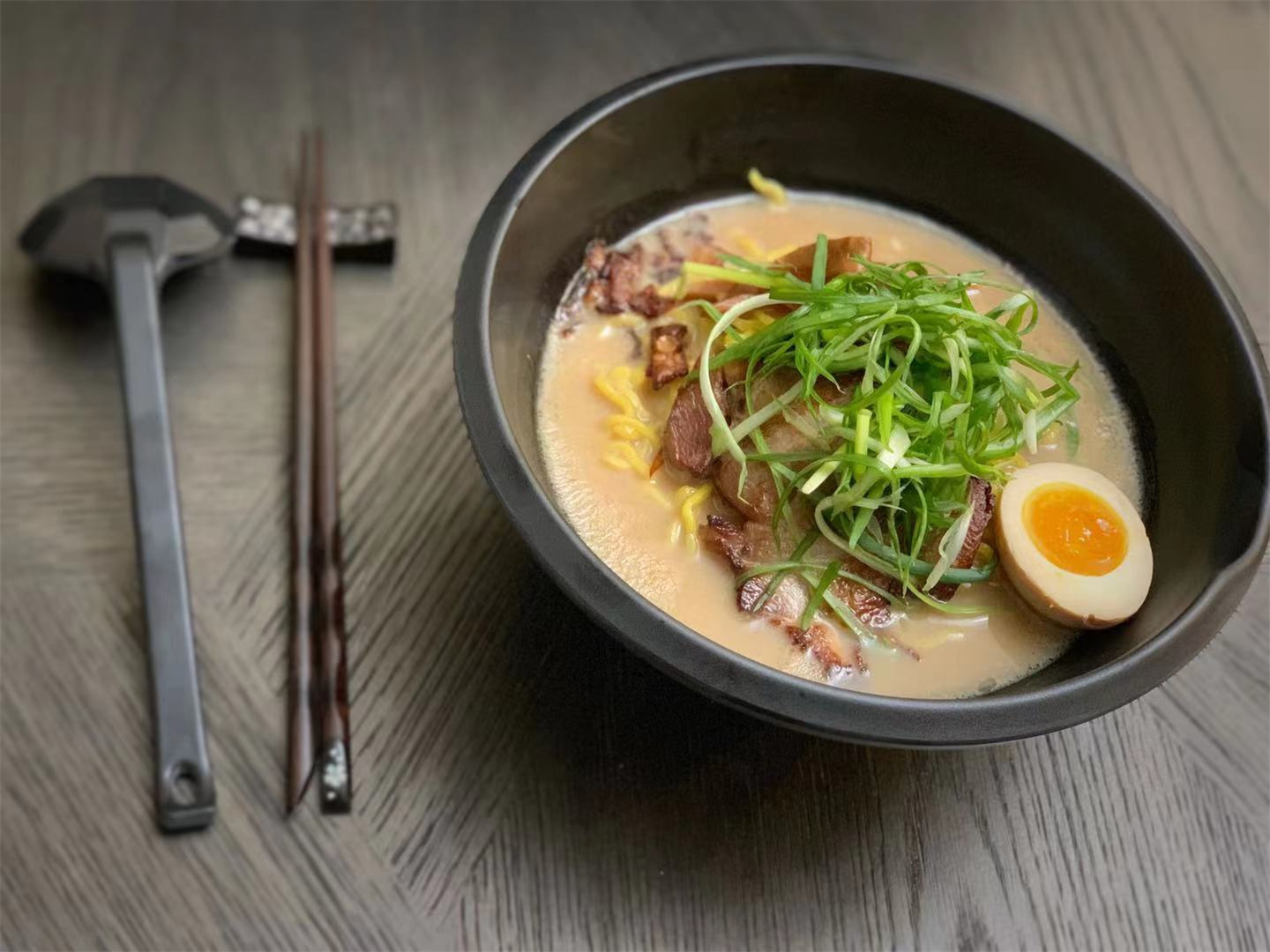 Bowl of creamy tonkotsu ramen topped with chashu, green onions and soft‑boiled egg at Ichitaru Ramen, a Ramen restaurant in Carlsbad
