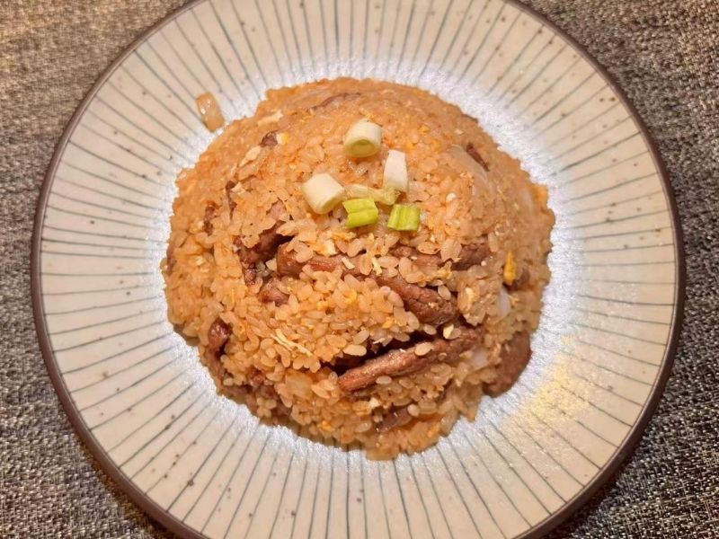 Fried rice mixed with beef and garnished with scallions at Ikyu Sushi II, a Japanese Restaurant in New York.