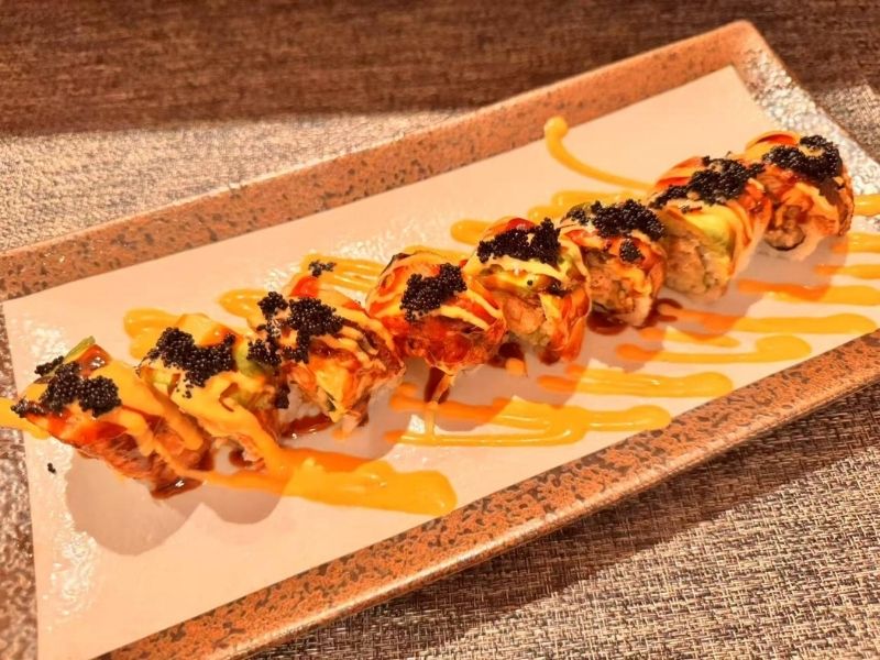 Ikyu-Sushi-II-Japanese-Restaurant-Black-Forest-Roll-New-York Sushi roll with toppings and drizzled sauces at Ikyu Sushi II, a Japanese Restaurant in New York.