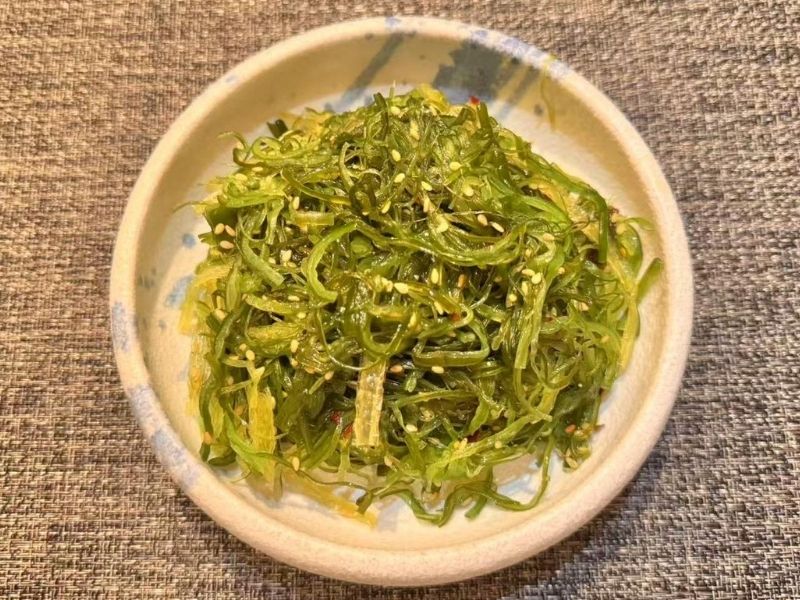 Bowl of seaweed salad with sesame seeds at Ikyu Sushi II, a Japanese Restaurant in New York.