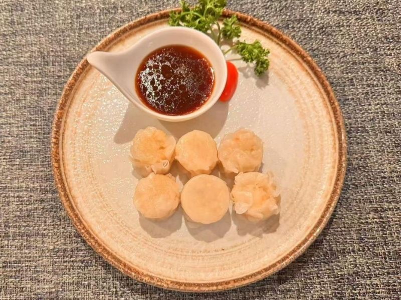 Plate of shrimp shumai with dipping sauce at Ikyu Sushi II, a Japanese Restaurant in New York.
