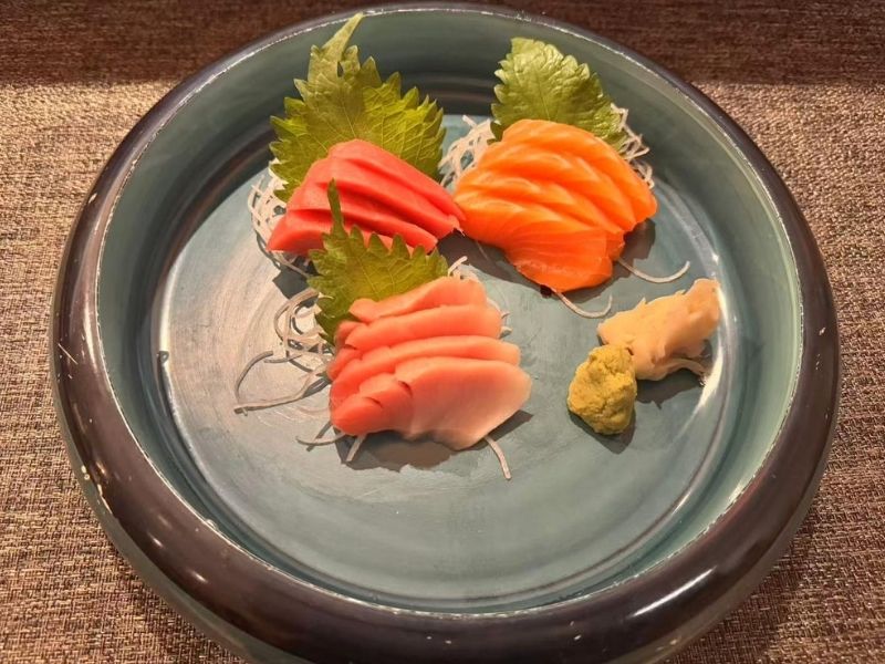 Plate of tri - color sashimi with garnishes at Ikyu Sushi II, a Japanese Restaurant in New York.