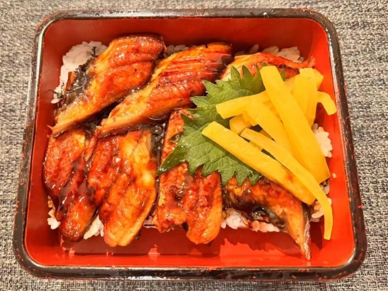 Box of unagi don with eel on top of rice at Ikyu Sushi II, a Japanese Restaurant in New York.