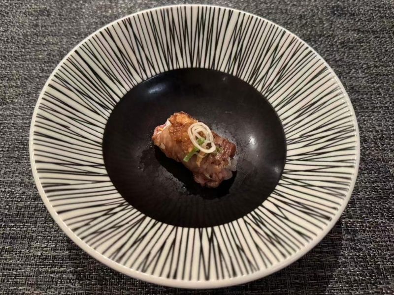 Piece of wagyu nigiri on a plate at Ikyu Sushi II, a Japanese Restaurant in New York.
