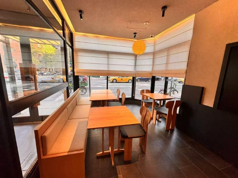 Ikyu-Sushi-II-Japanese-Restaurant-Window-Seating-New-York Wooden tables and chairs, and large windows offering a view of the street outside, a Japanese Restaurant in New York.