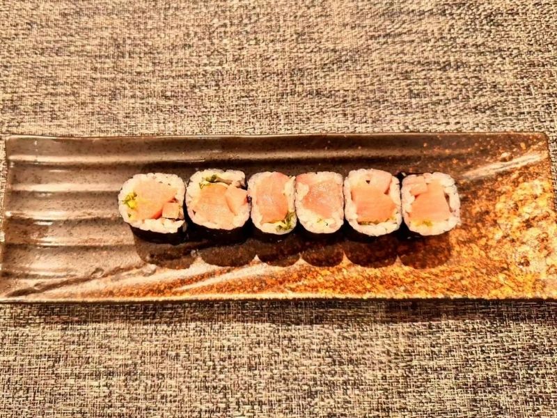 Yellowtail scallion sushi roll on a plate at Ikyu Sushi II, a Japanese Restaurant in New York.