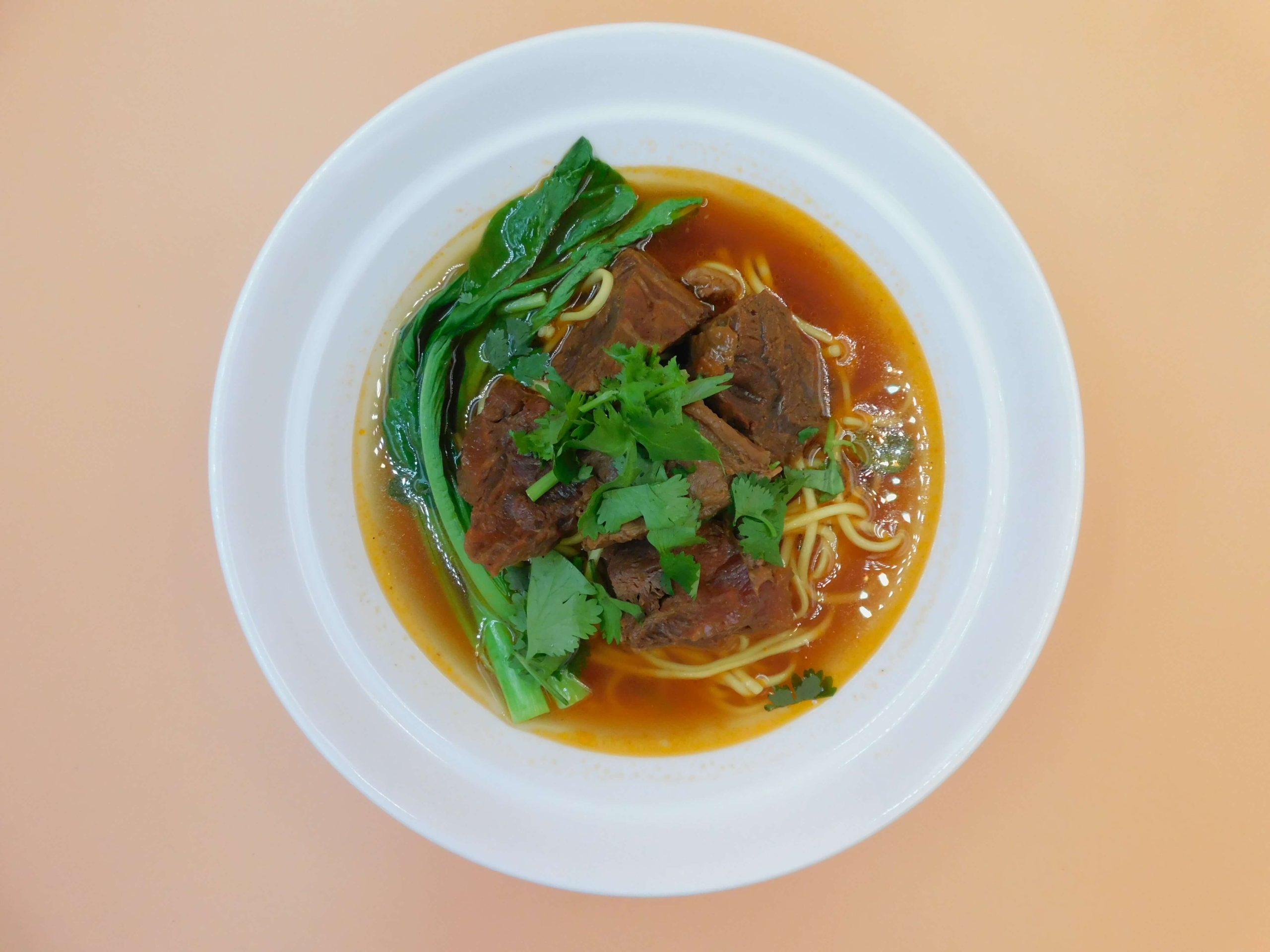 Spicy beef noodle soup with tender beef chunks and greens at Okinii Japanese Restaurant & Impressive Noodle, a Asian Fusion Restaurant in Massapequa