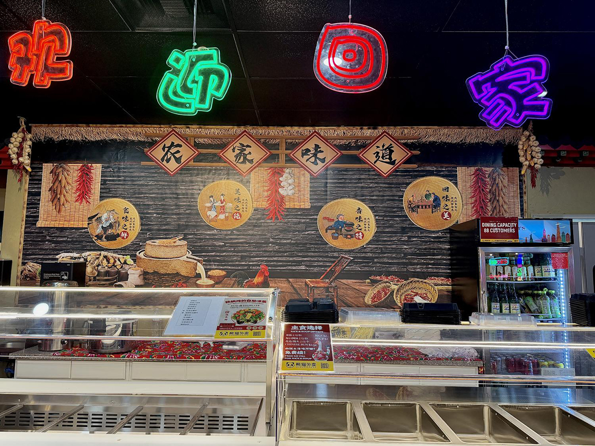 Neon sign for Tie Dun Jia with wall art and garlic at Iron Pot Stew Kitchen, a Chinese Restaurant in Santa Clara