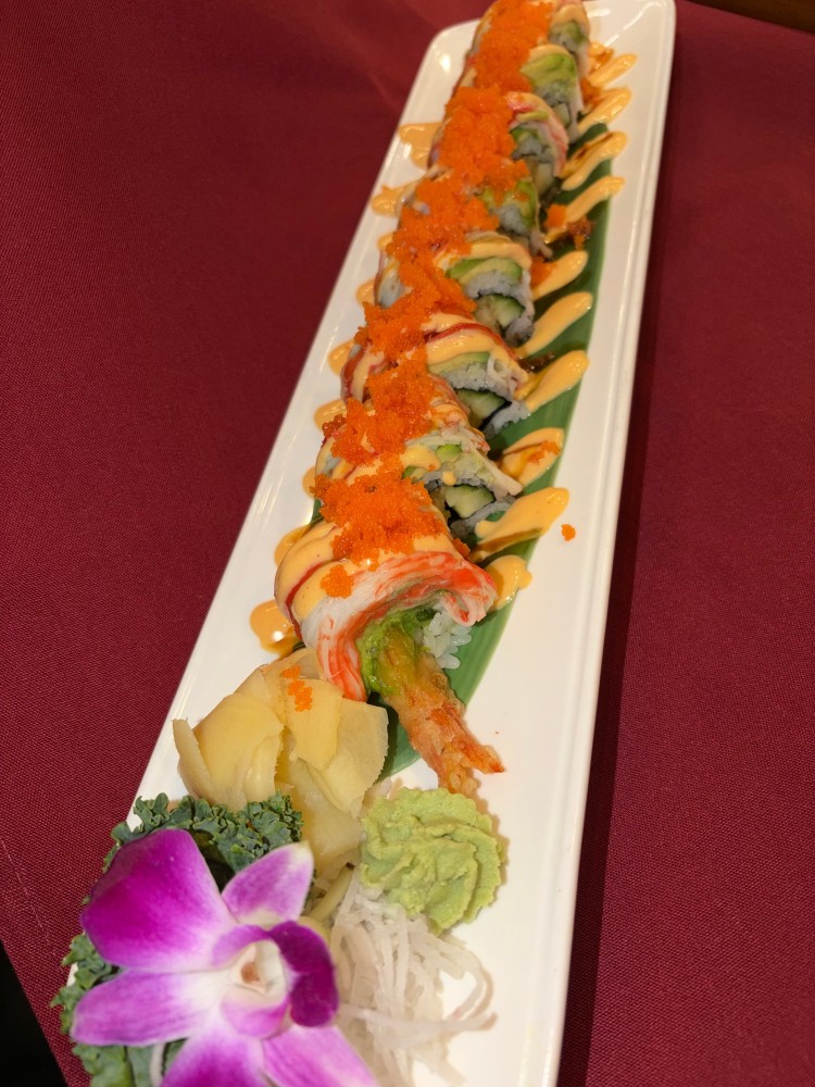 Sushi roll topped with crab stick, tobiko and creamy spicy sauce