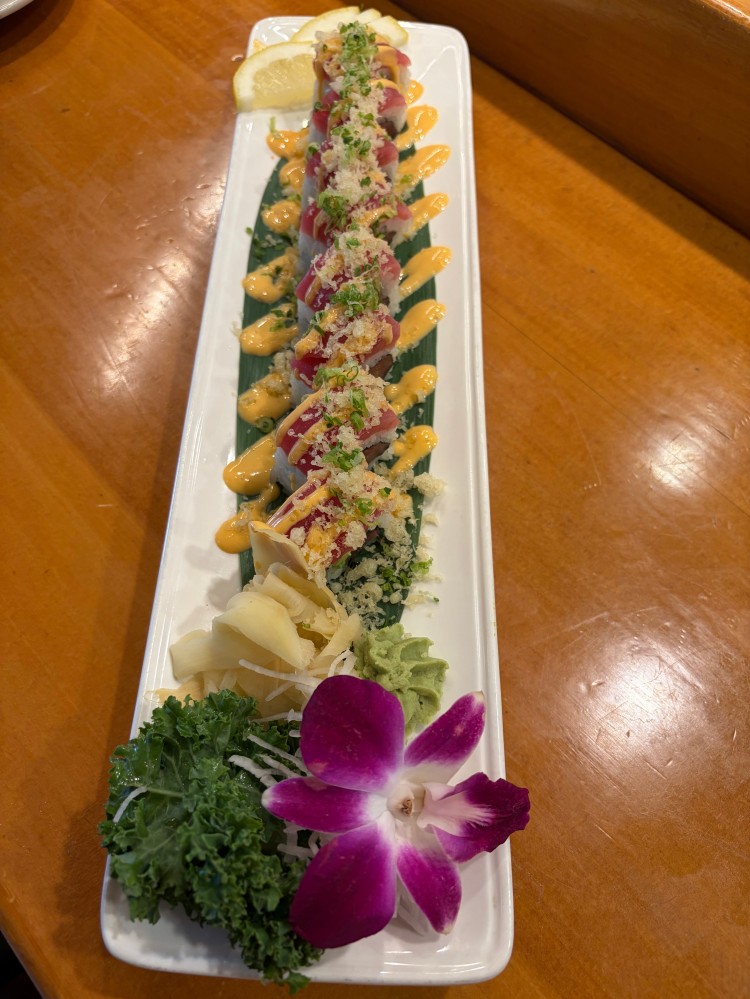 Tuna sushi roll with crispy crumbs, spicy sauce and fresh garnish