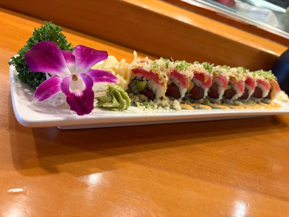 Tuna sushi roll with crispy crumbs, spicy sauce and purple orchid