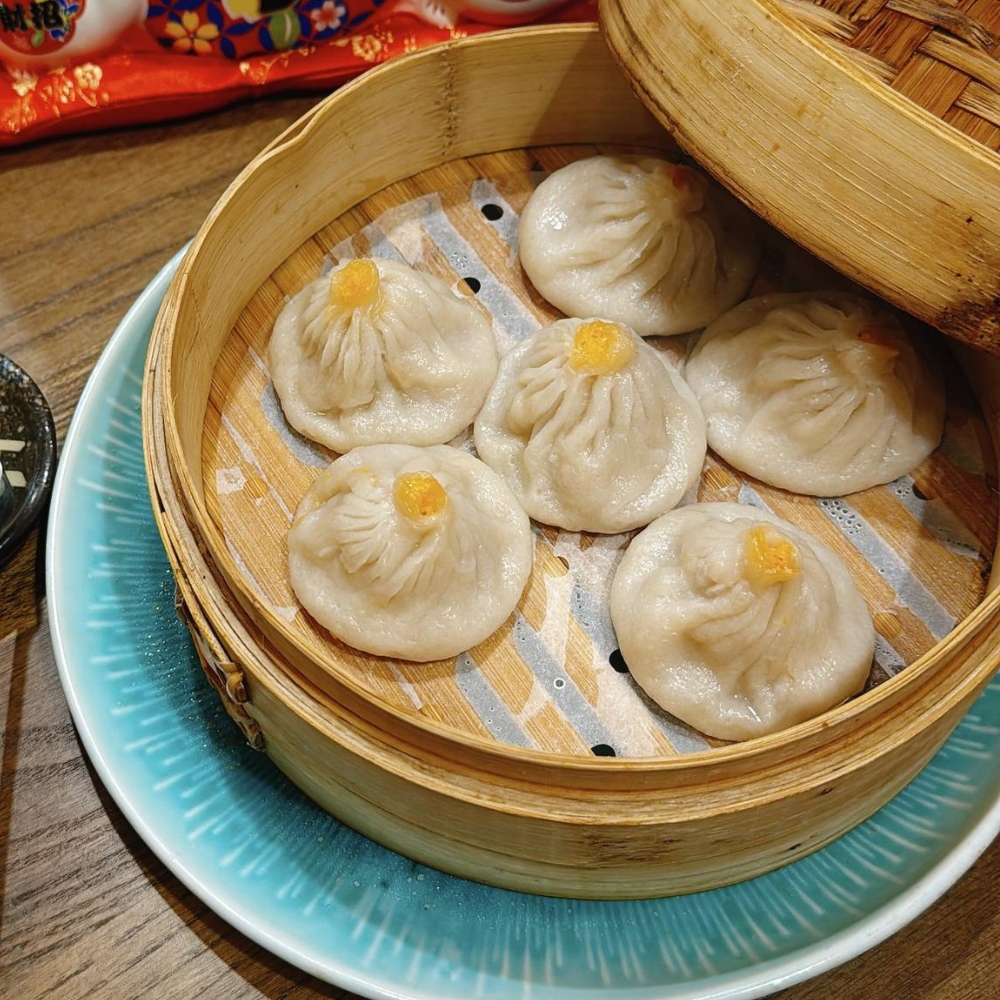 Steamed crab roe soup dumplings in bamboo steamer at JBC Rice Noodles Ramen & Dumplings, a Asian Restaurant in Astoria