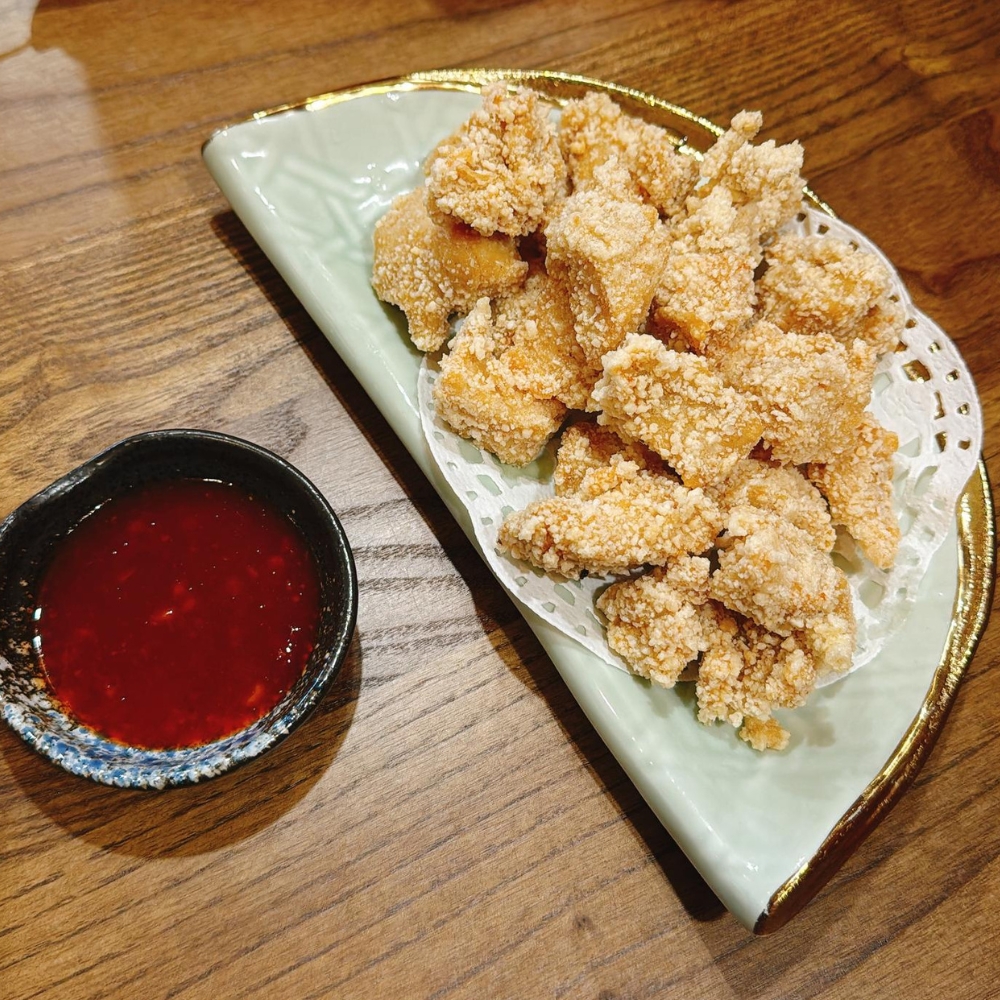 Crispy chicken bites served with red dipping sauce at JBC Rice Noodles Ramen & Dumplings, a Asian Restaurant in Astoria