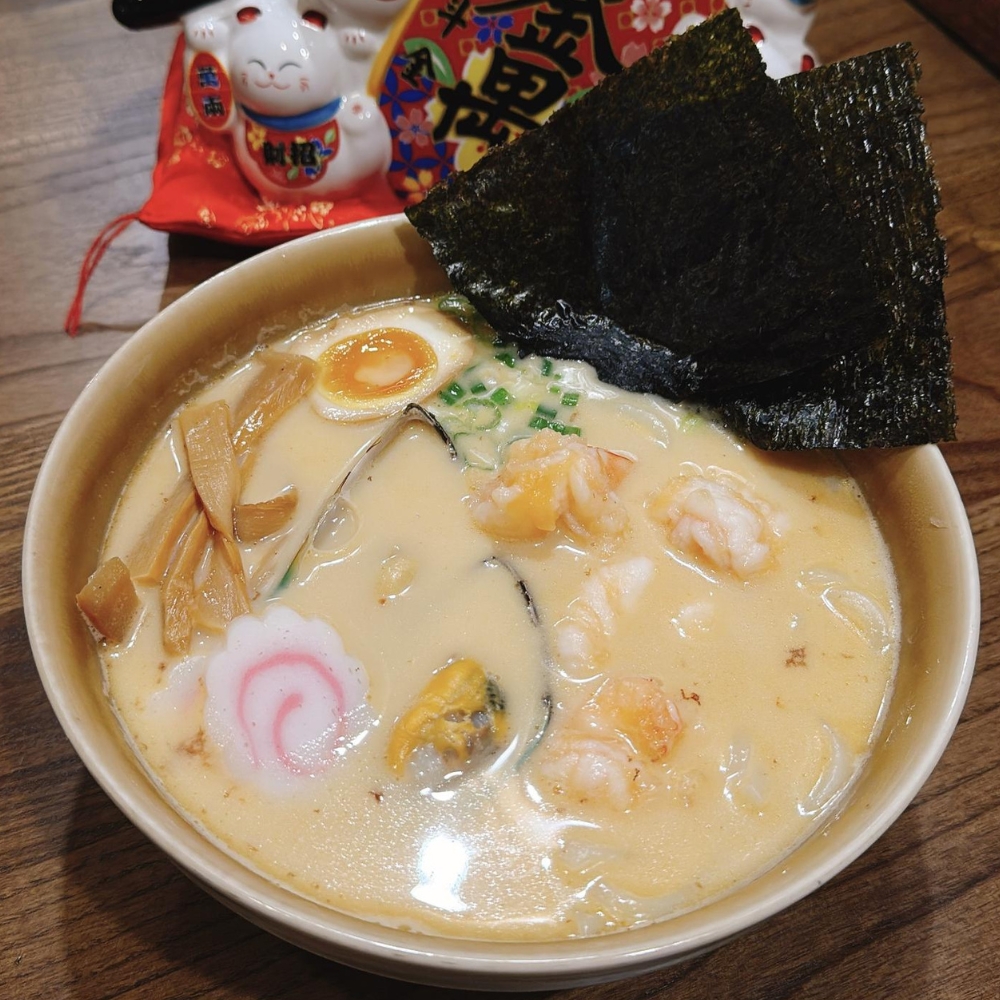 Creamy seafood ramen with shrimp, mussels, egg, bamboo shoots, nori and fish cake at JBC Rice Noodles Ramen & Dumplings, a Asian Restaurant in Astoria