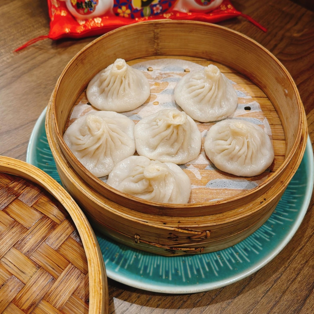 Steamed soup dumplings in bamboo steamer at JBC Rice Noodles Ramen & Dumplings, a Asian Restaurant in Astoria
