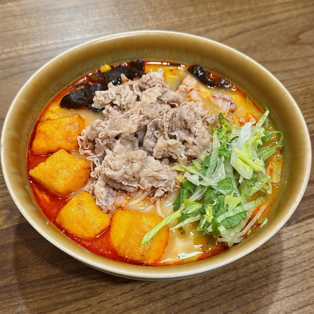 Spicy hot pot rice noodles with beef slices, tofu puffs, black fungus and lettuce at JBC Rice Noodles Ramen & Dumplings, a Asian Restaurant in Astoria