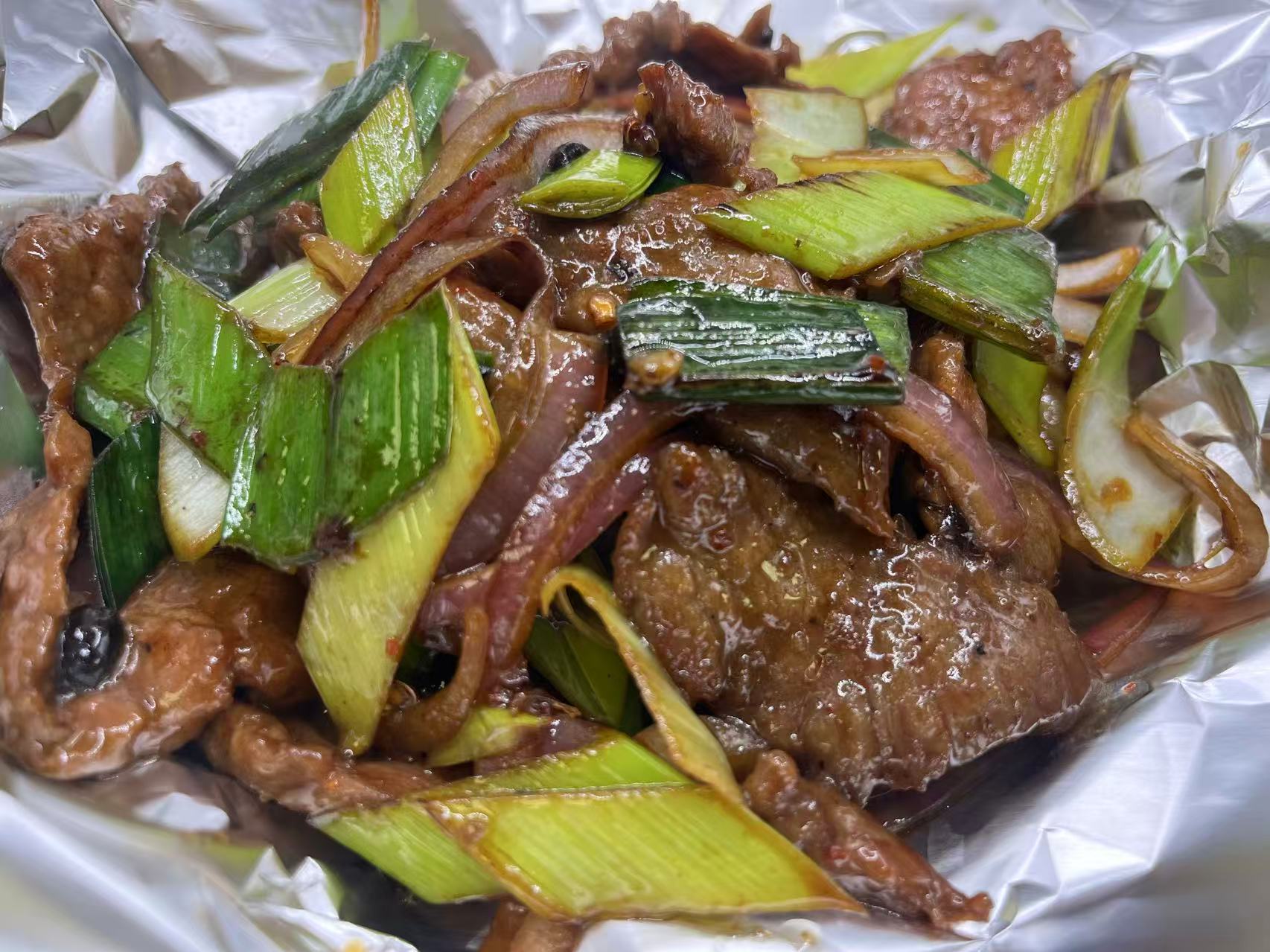 Stir-fried beef with green scallion and red onion in foil wrap at JiangNan Philadelphia, a Chinese Restaurant in Philadelphi