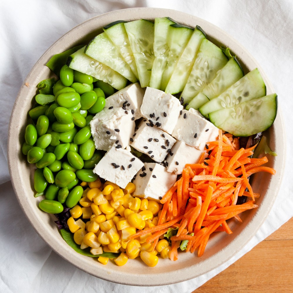 Colorful plant-based bowl with edamame, tofu, cucumber, corn, shredded carrot, and greens at Joe's Yummy Bowl，a Asian Restaurant in Flint