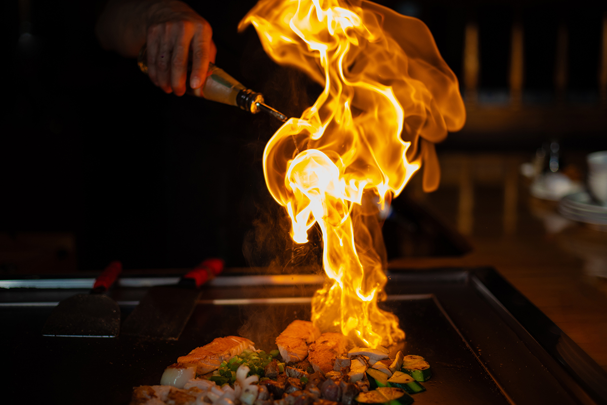 cooking vegetables meat and seafood on hot hibachi grill table. Traditional Japanese Cuisine