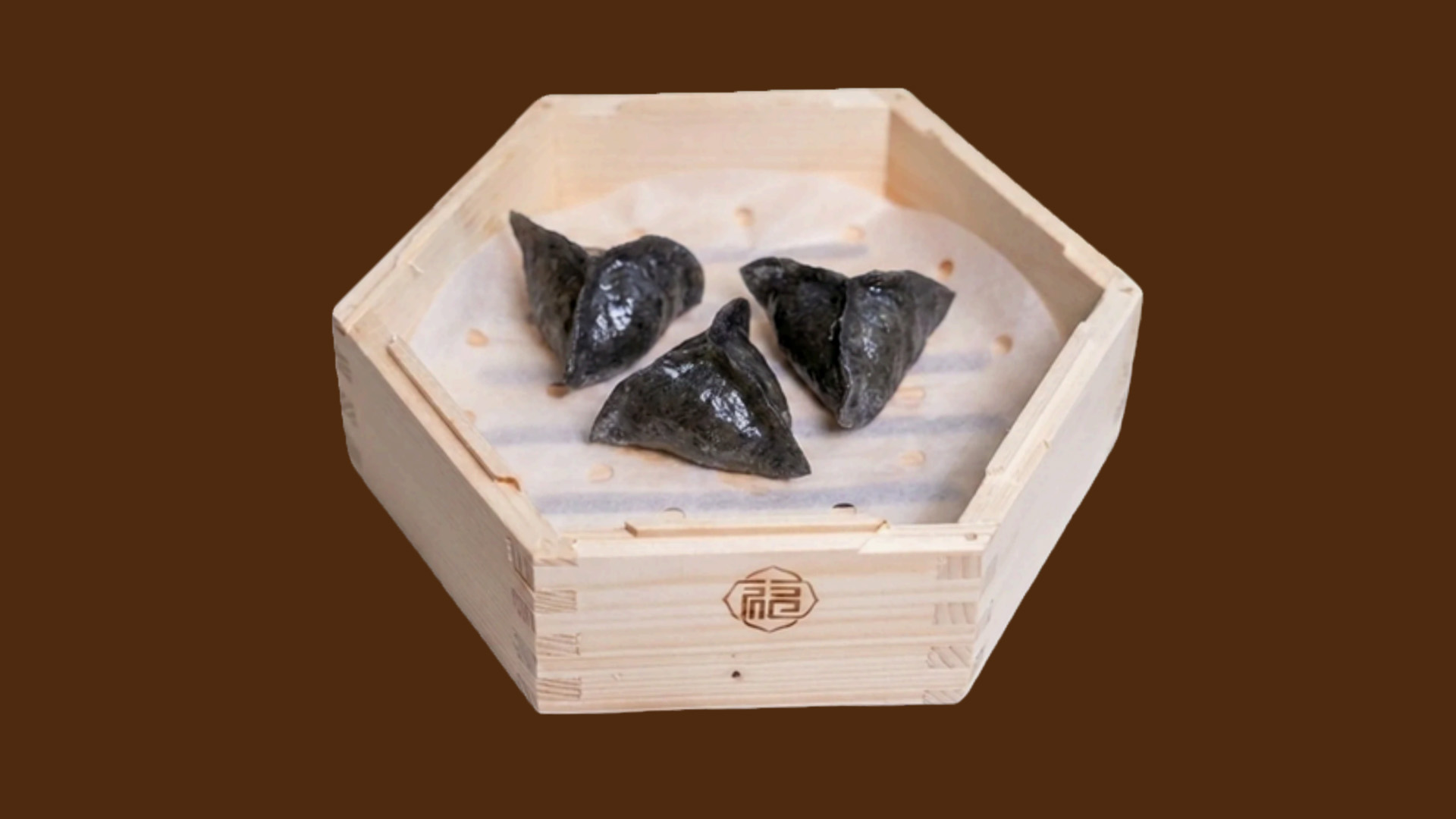 Three black squid crystal dumplings in hexagonal wooden tray at JoyFu Dim Sum, a Dim Sum Restaurant in New York