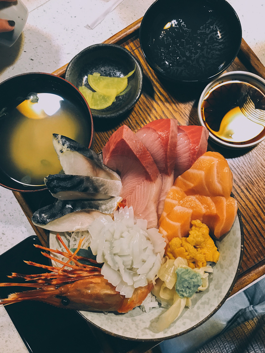 Fresh sushi and sashimi combination platter served with traditional Japanese sides