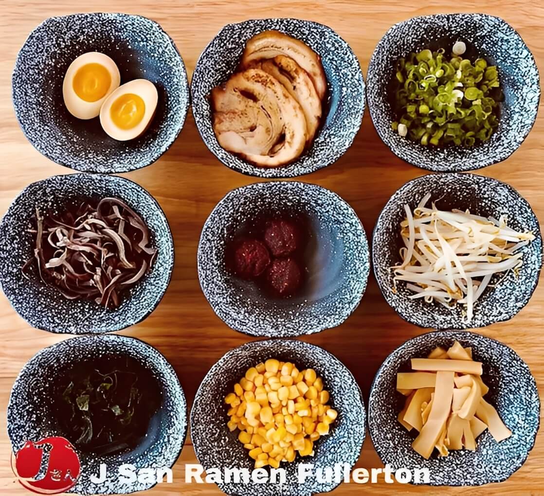 Assorted fresh ramen side ingredients in small bowls.