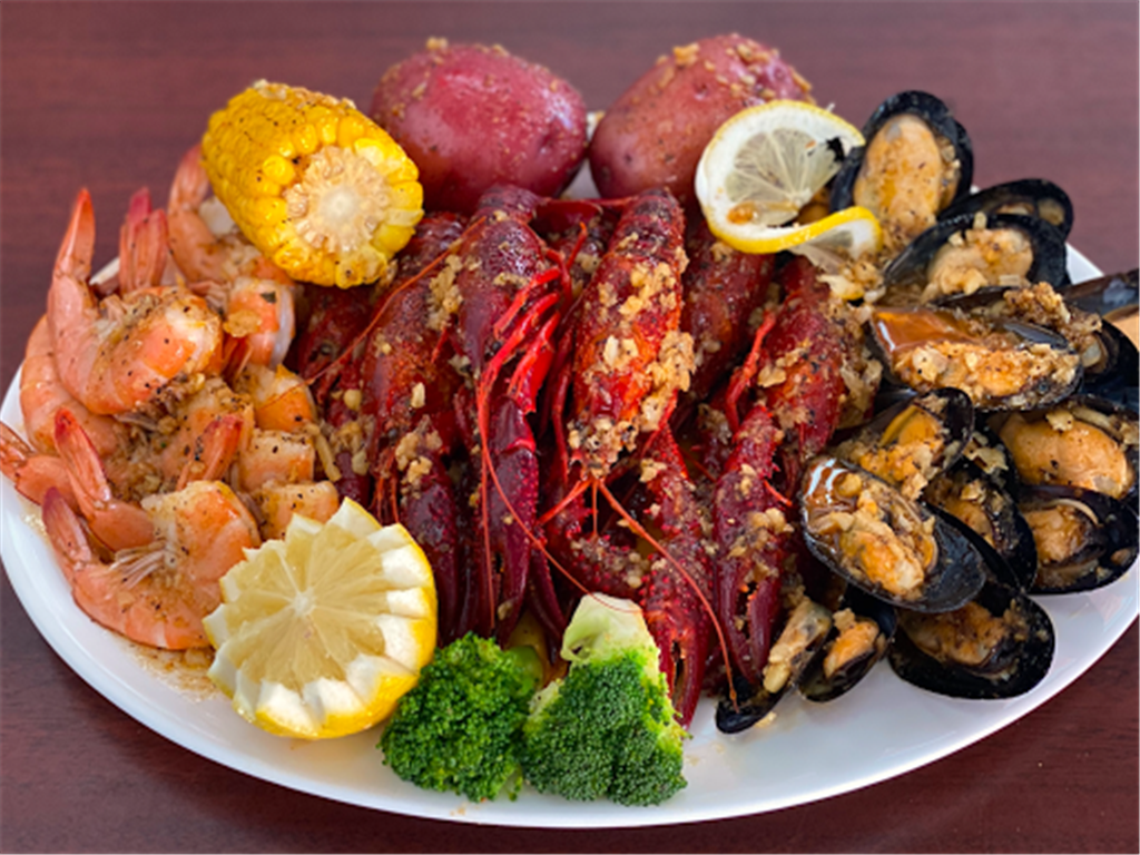 Seafood boil platter with crawfish, shrimp, mussels, corn, potato and lemon