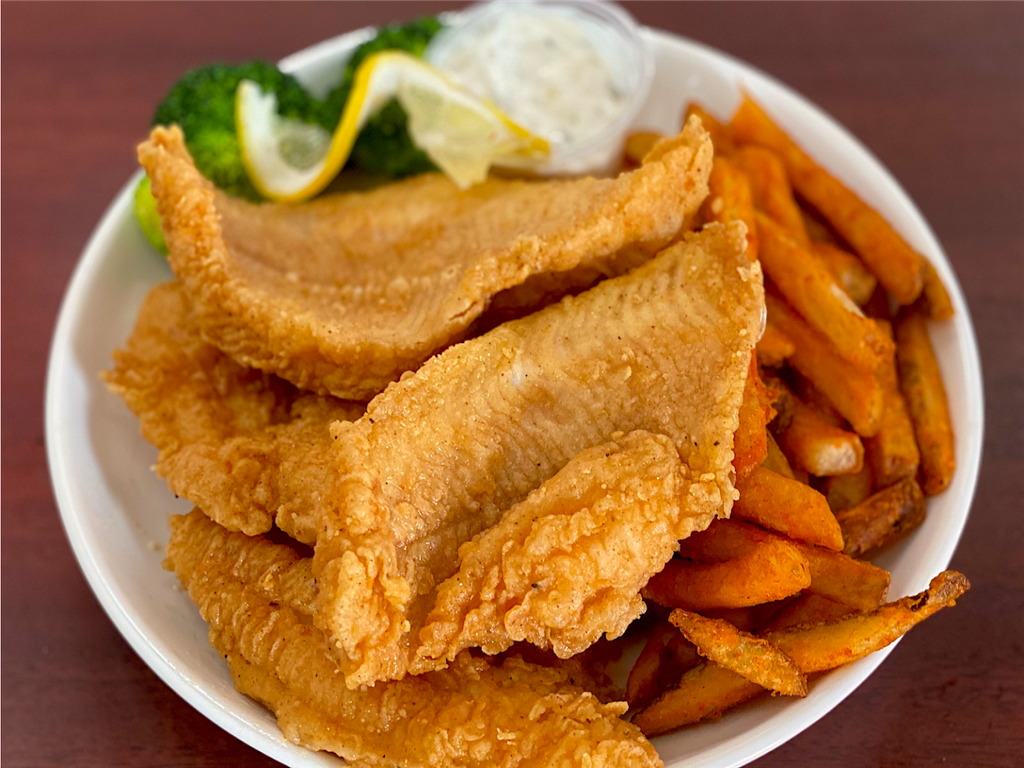 Golden fried fish fillets with sweet potato fries, broccoli, lemon and tartar sauce