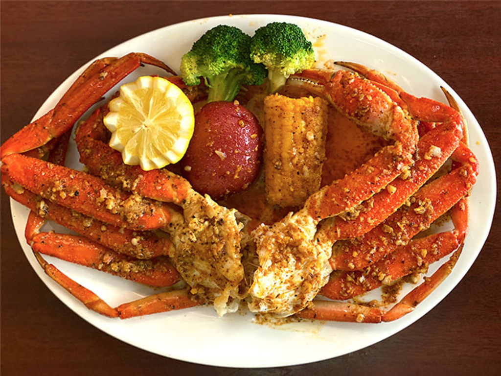 Seasoned snow crab legs served with corn, potato, broccoli and lemon