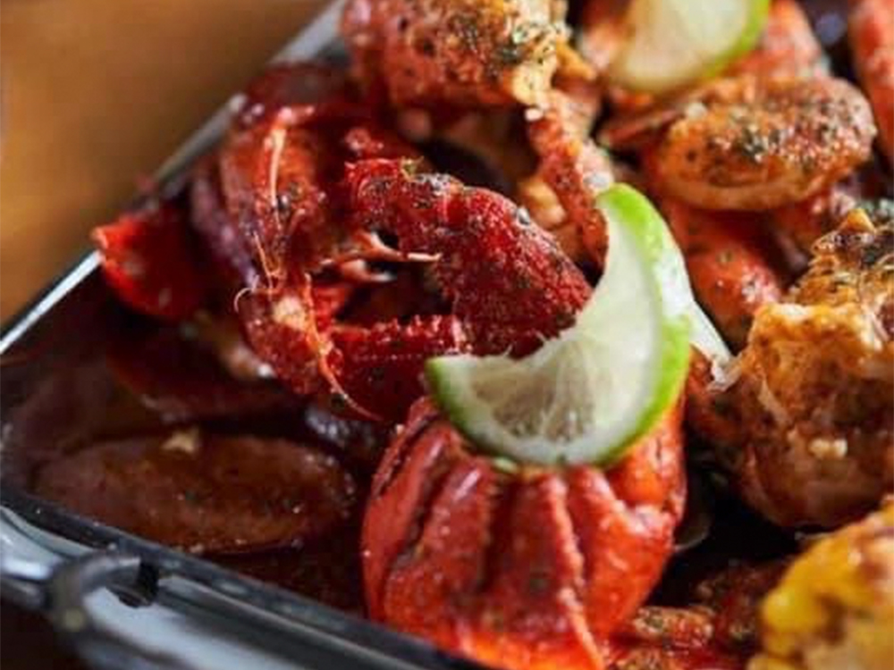 Giant king crab legs platter with fresh lime slices at The Juicy Seafood-Pearl, a Seafood in Pearl