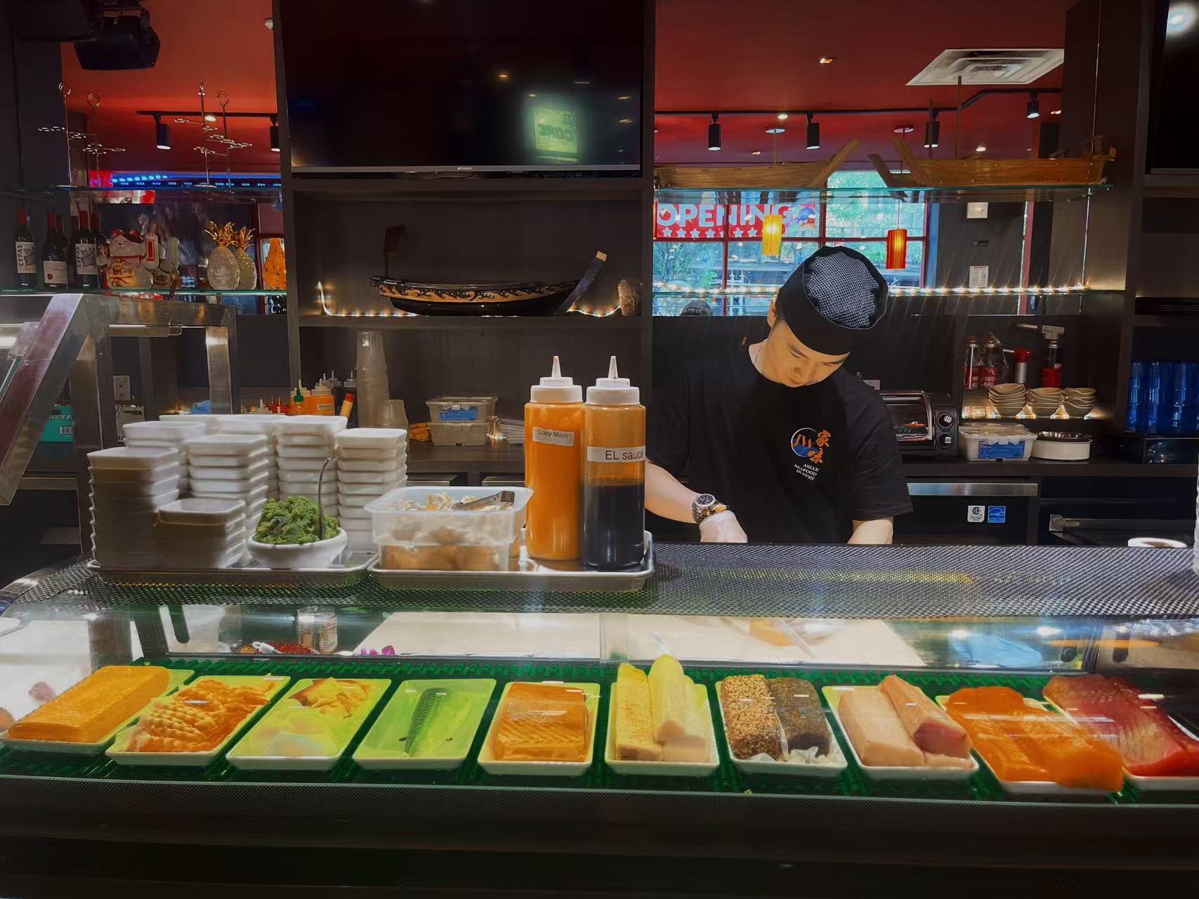 Sushi Prep - A chef preparing sushi with fresh raw fish and other ingredients at JW Asian Seafood Buffet, a Buffet restaurant in Long Island City