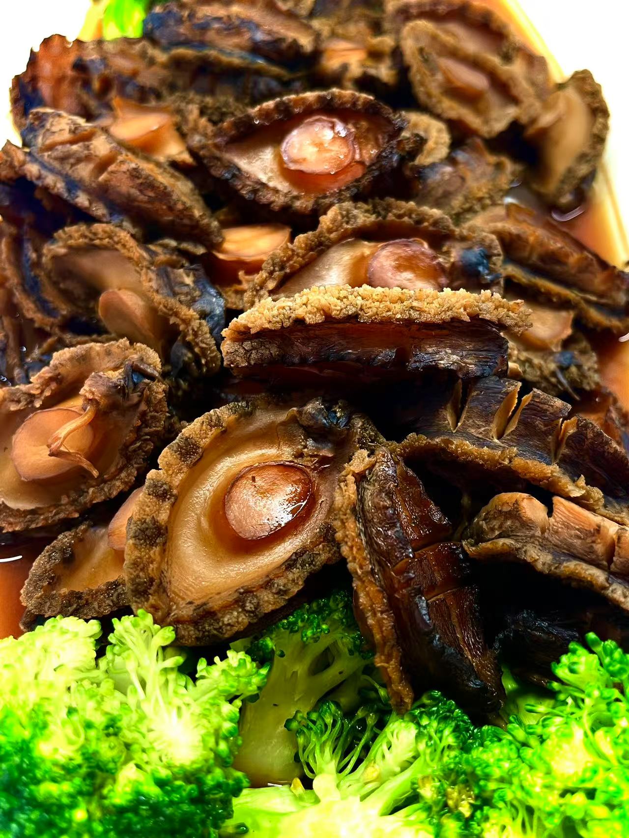 Braised Abalone - Tender abalones in a savory sauce, accompanied by broccoli at JW Asian Seafood Buffet, a Buffet restaurant in Long Island City