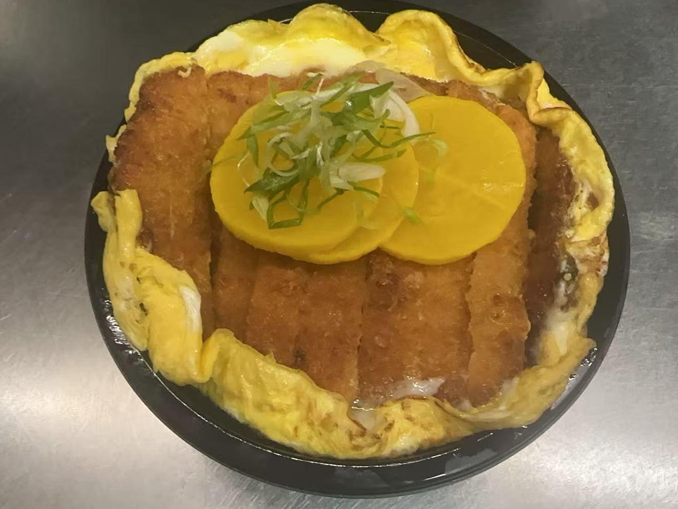Pork Cutlet Egg Bowl Crispy pork cutlet with egg and rice at Kakkoii Sushi and Ramen, a Japanese restaurant in Malden