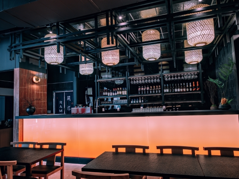 Modern dining area with bar and warm lighting at Kanpai Ramen, a Ramen Restaurant in New Port Richey