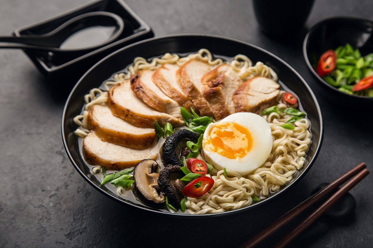 Japanese ramen with sliced chicken, soft-boiled egg, mushrooms, and chili peppers
