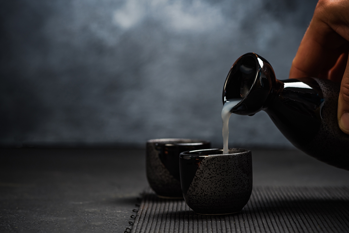 Japanese sake being poured into a ceramic cup