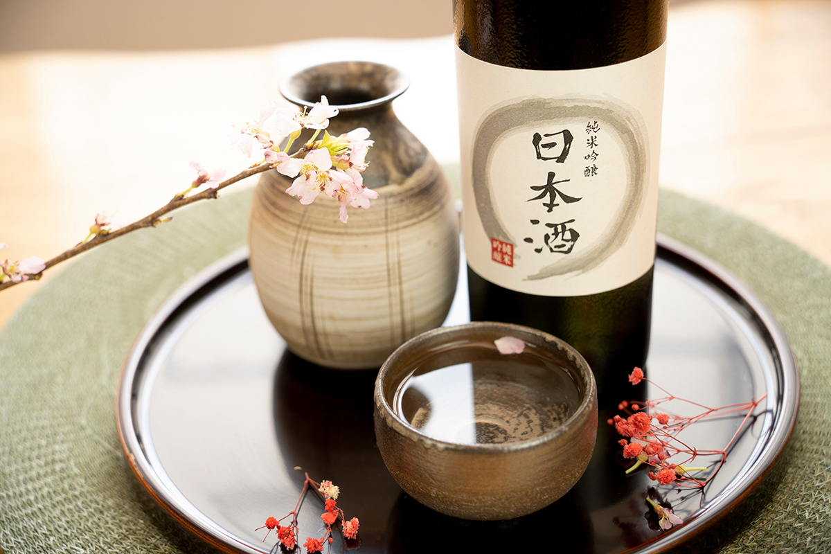 Japanese sake bottle and cup arranged with cherry blossoms