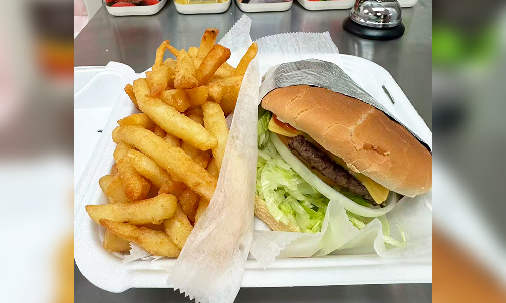 A cheeseburger with lettuce, onion, cheese, and a side of French fries at Kick Off Wings, a Fast Food Restaurant in Carrollton