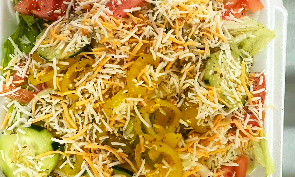 A garden salad with cucumbers, tomatoes, peppers, and shredded cheese at Kick Off Wings, a Fast Food Restaurant in Carrollton
