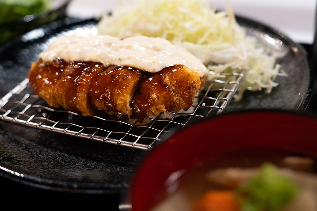 Close‑up of tonkatsu with sauce and creamy dressing
