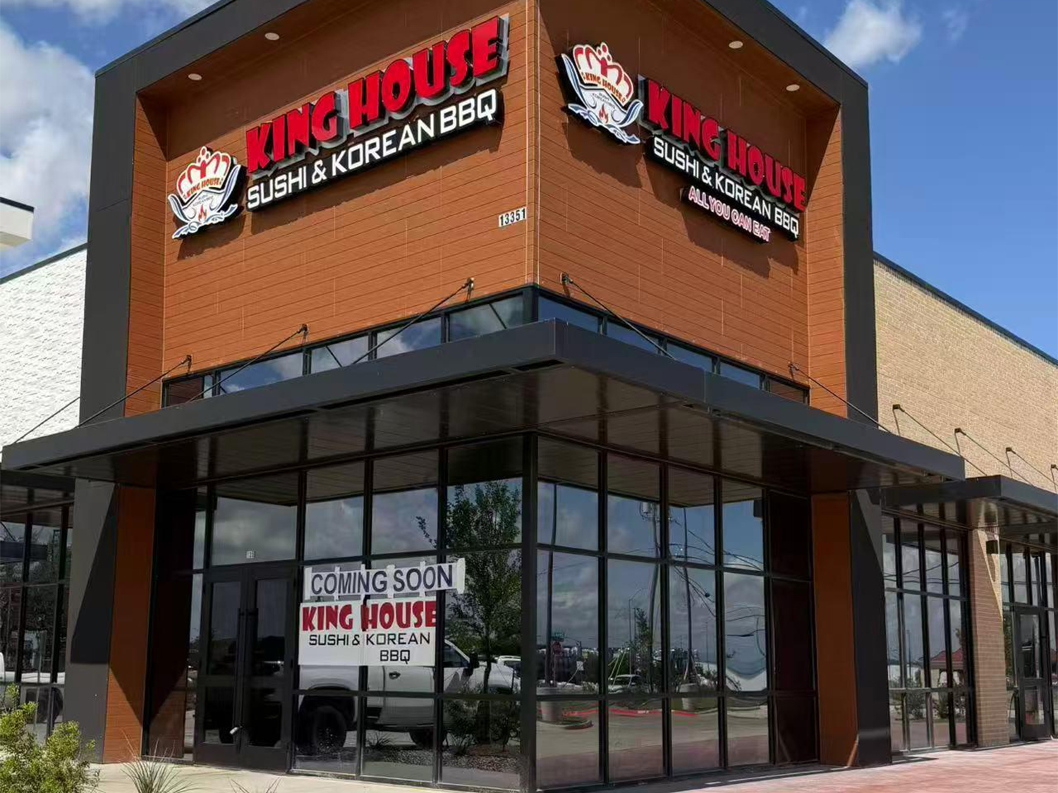 Storefront of King House Sushi & Korean BBQ with a "Coming Soon" sign and brown wood-style siding.