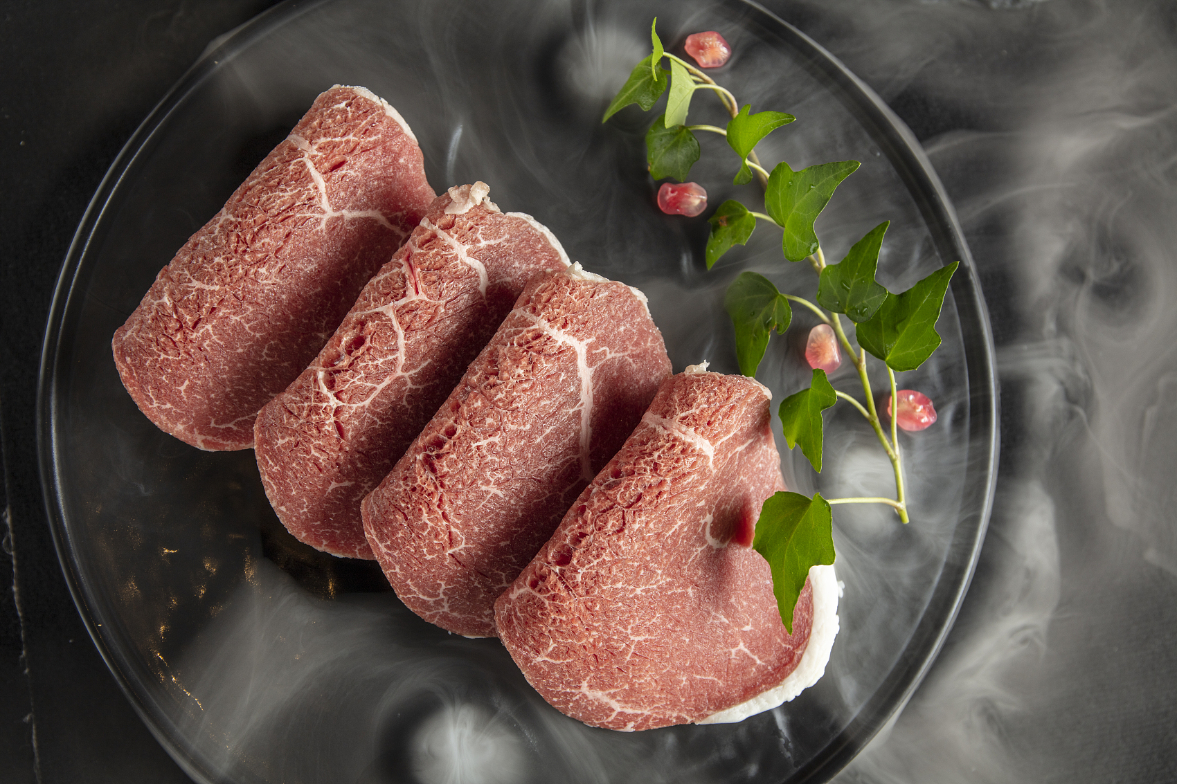 Marbled snowflake beef slices on a glass plate at King Pot Korean BBQ & Hot Pot, a Asian Fusion restaurant in Greeley