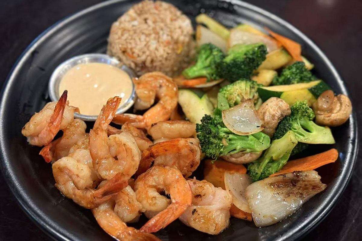 Grilled shrimp with fried rice mixed veggies and creamy sauce on black plate at Kings Sushi, a Japanese Restaurant in Summerville