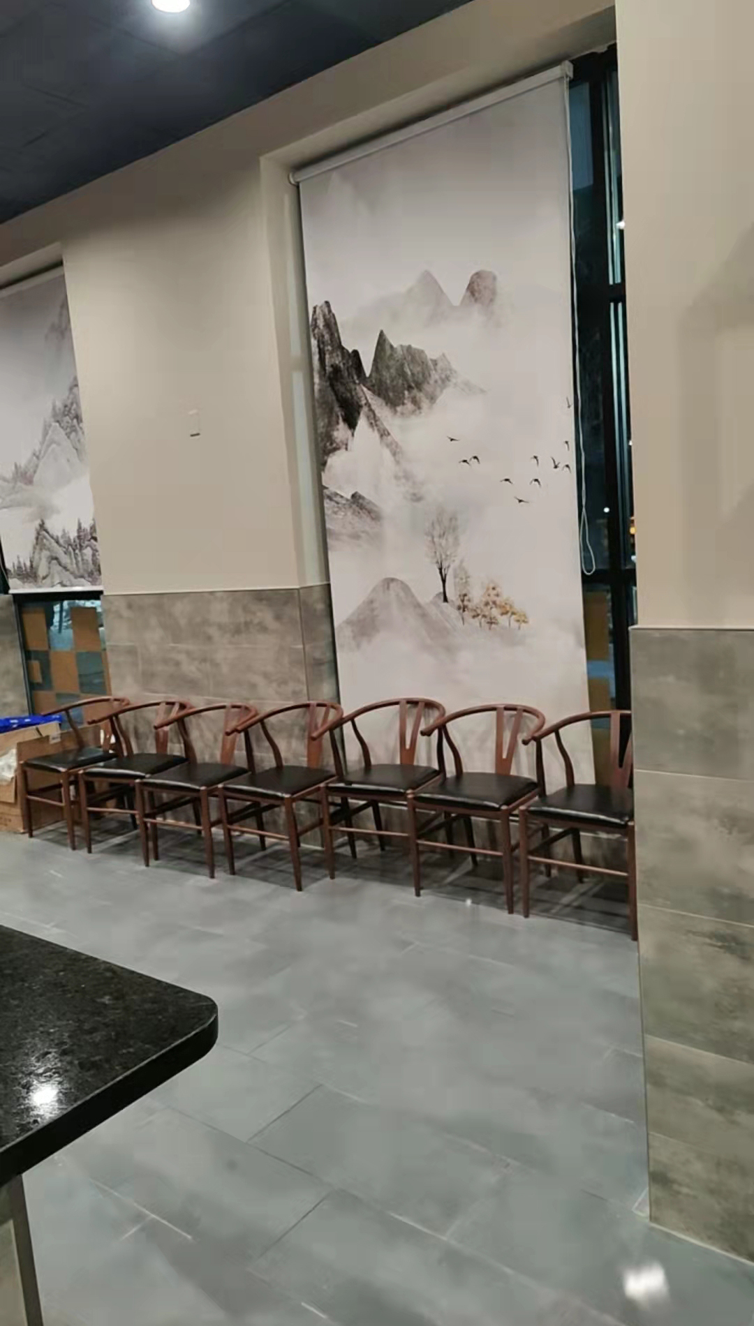 Wooden chairs with black seats by the window at Kirin Hot Pot, a Chinese Restaurant in Broomfield